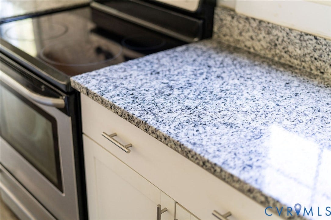 14043 Jefferson Highway, Louisa, VA 23024 Stone-surface countertops, white cabinetry with metallic pulls, and stainless steel smooth-top range