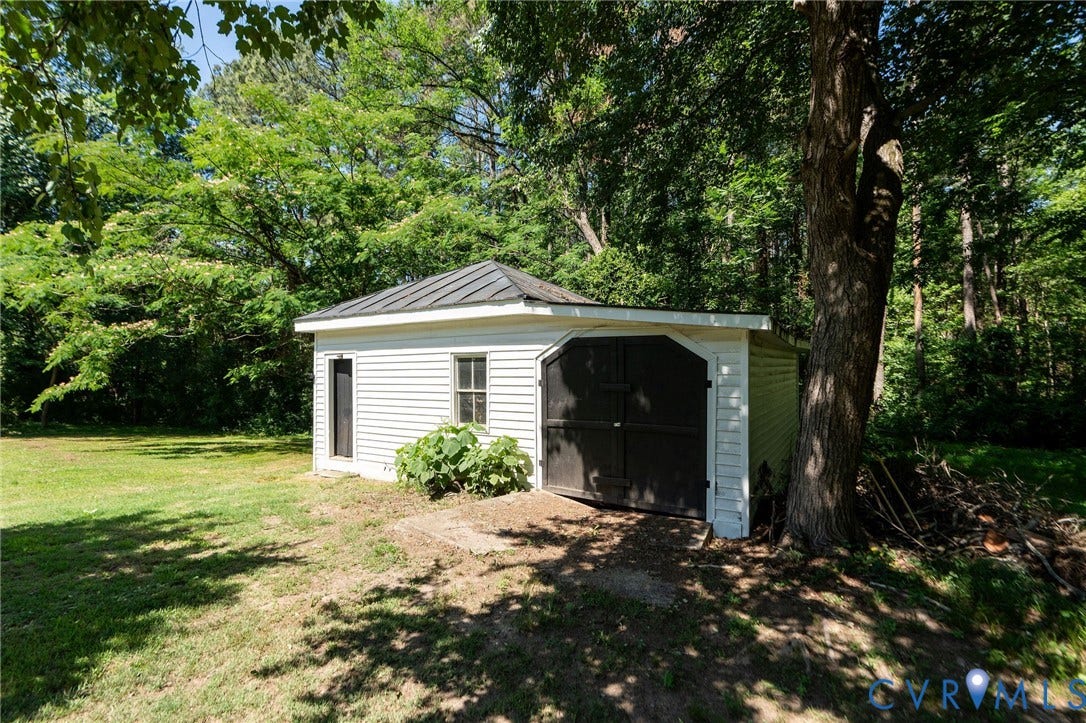 14043 Jefferson Highway, Louisa, VA 23024 Detached garage with horizontal siding, a metal roof, and arched double doors, situated on a lot with mature trees