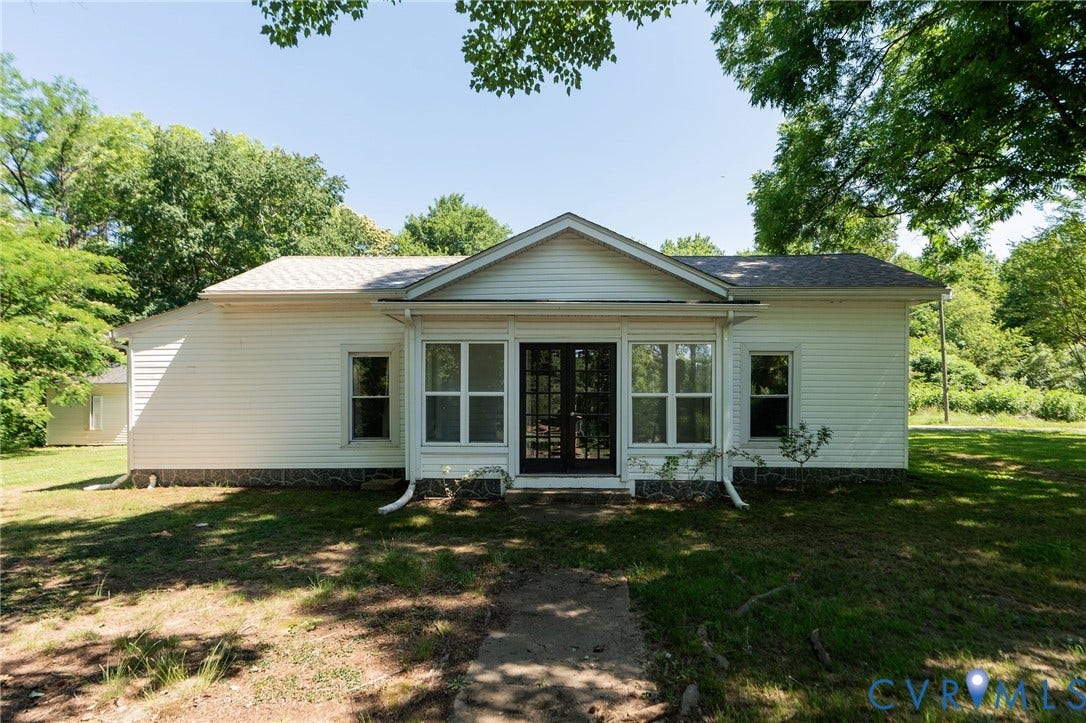 14043 Jefferson Highway, Louisa, VA 23024 Single-story residence with white horizontal siding, gabled roofline, dark-framed glass paneled double entry doors, and multi-pane windows
