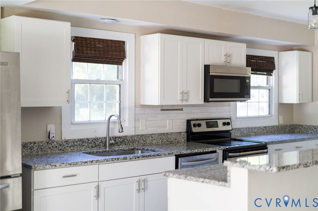 14043 Jefferson Highway, Louisa, VA 23024 Kitchen featuring white shaker-style cabinetry, speckled stone-finish countertops, white subway tile backsplash, stainless steel appliances, and a gooseneck faucet