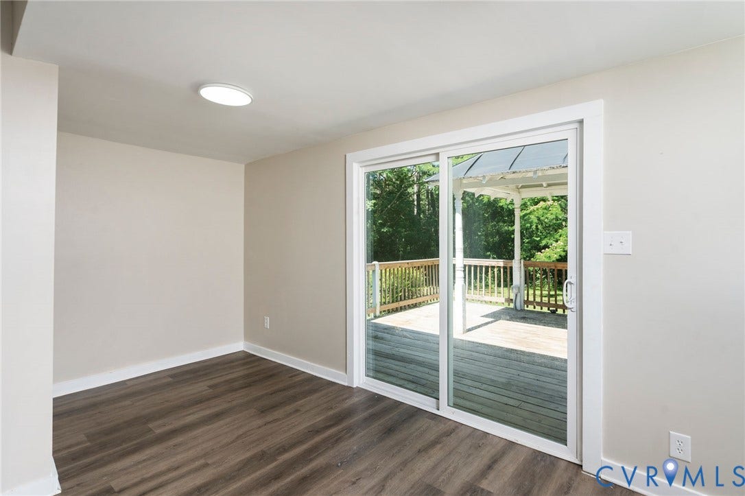 14043 Jefferson Highway, Louisa, VA 23024 Interior space featuring wood-finish flooring, neutral wall paint, flush-mount ceiling lighting, and sliding glass doors providing outdoor access to a wood deck with a gazebo