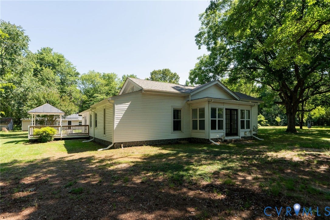 14043 Jefferson Highway, Louisa, VA 23024 Exterior featuring horizontal siding, a multi-pane glass door, a detached gazebo with a wood deck, and expansive grounds with mature trees
