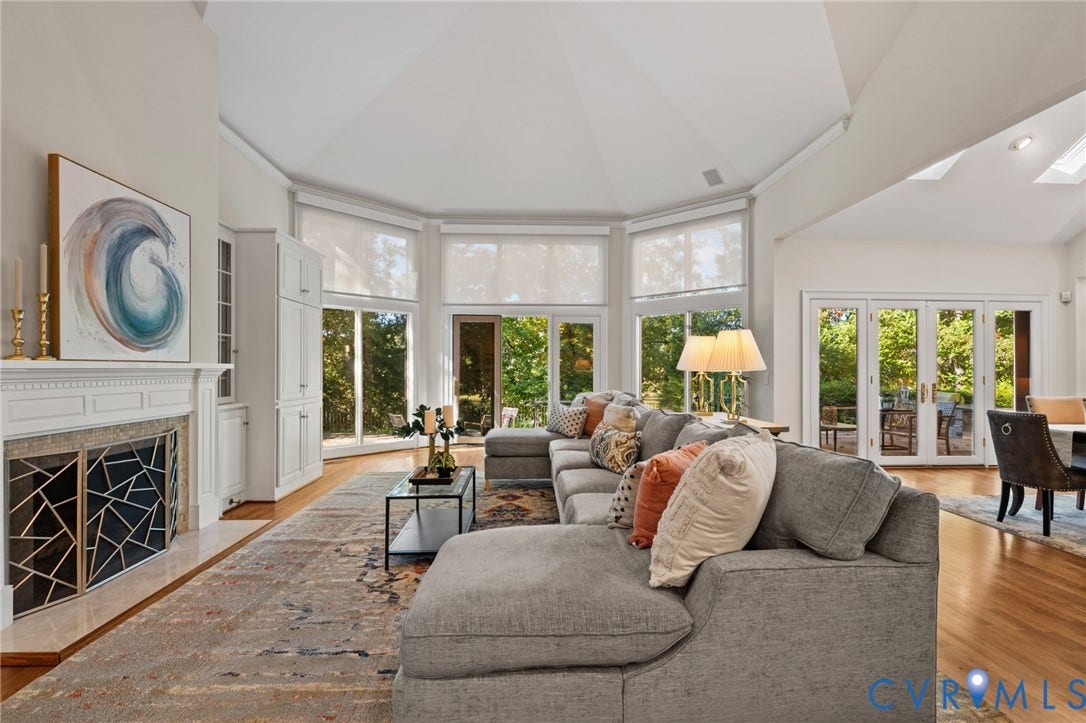 11429 Barrington Bridge Court, Henrico, VA 23233 Vaulted ceilings, fireplace with custom geometric metal screen, built-in cabinetry, wood-finish flooring, and expansive windows