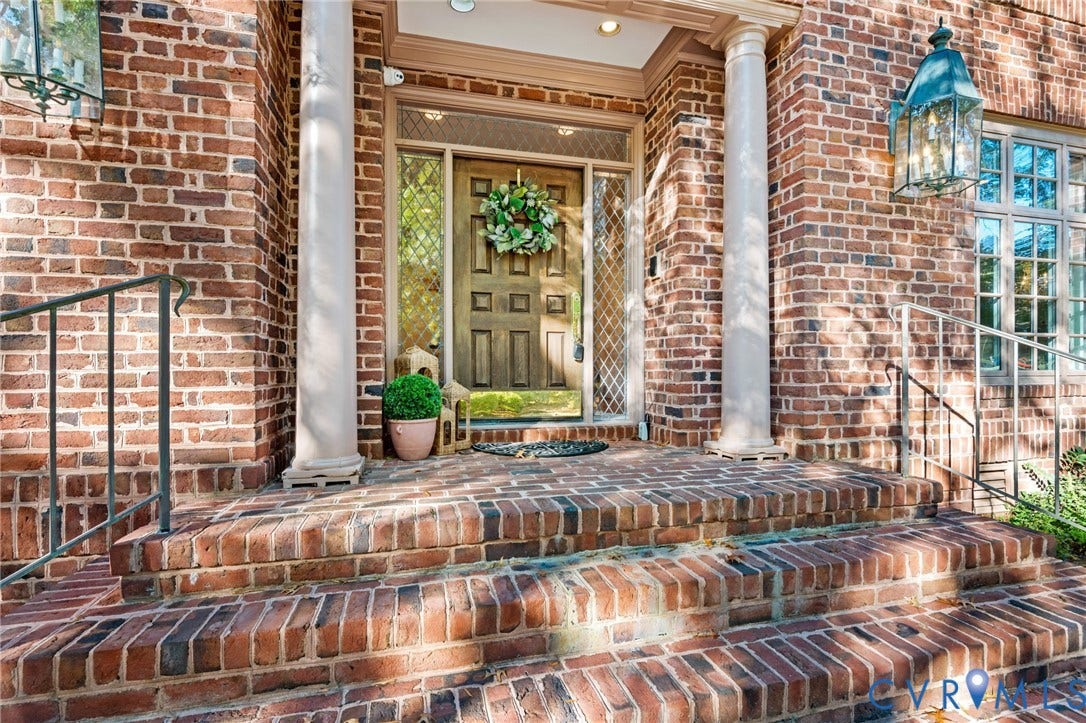 11429 Barrington Bridge Court, Henrico, VA 23233 Classic brick exterior featuring a multi-step brick entryway, dual architectural columns, side-light windows with patterned detailing, and metal-cased carriage-style lanterns
