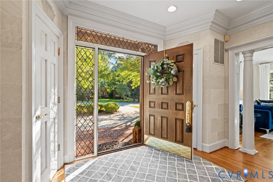 11429 Barrington Bridge Court, Henrico, VA 23233 Foyer entrance featuring a solid wood paneled door, diamond-patterned leaded glass sidelight, stone-textured wall finishes, recessed lighting, and a columned entryway