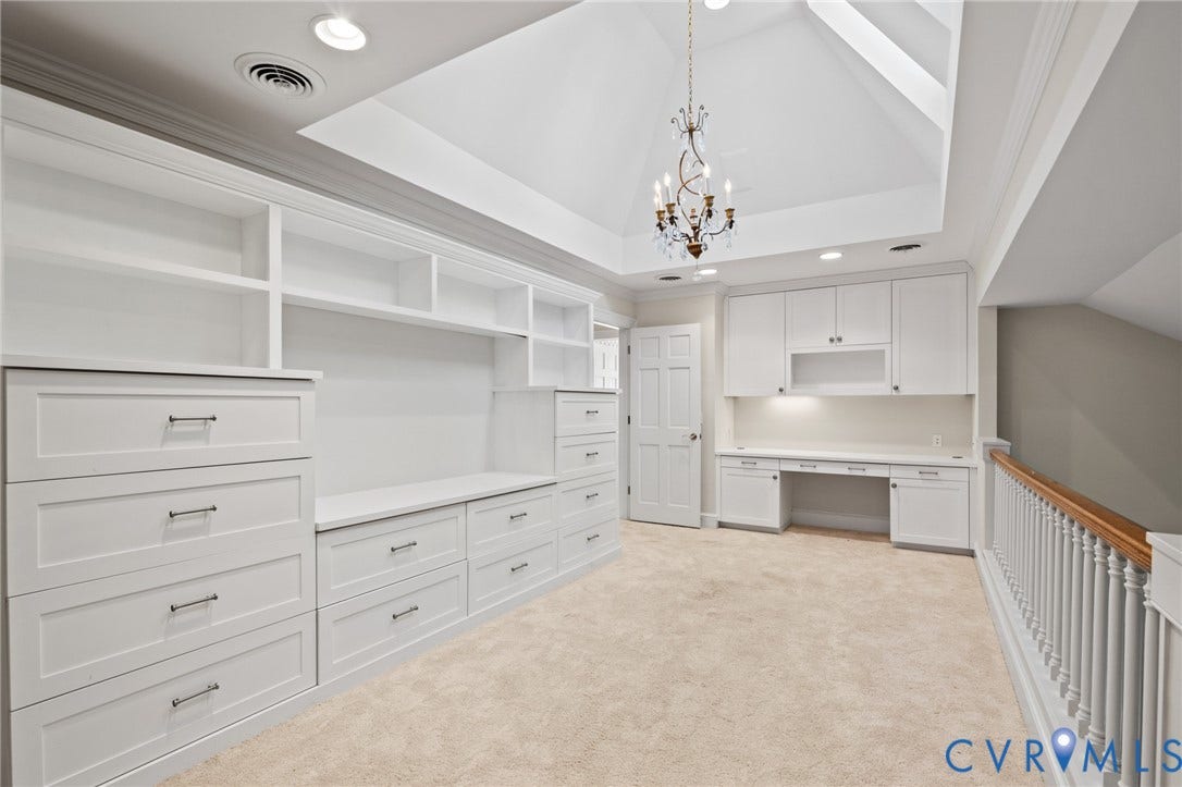 11429 Barrington Bridge Court, Henrico, VA 23233 Vaulted ceiling featuring a decorative chandelier, extensive custom built-in white cabinetry, integrated desk workspace, and a classic wood-capped railing