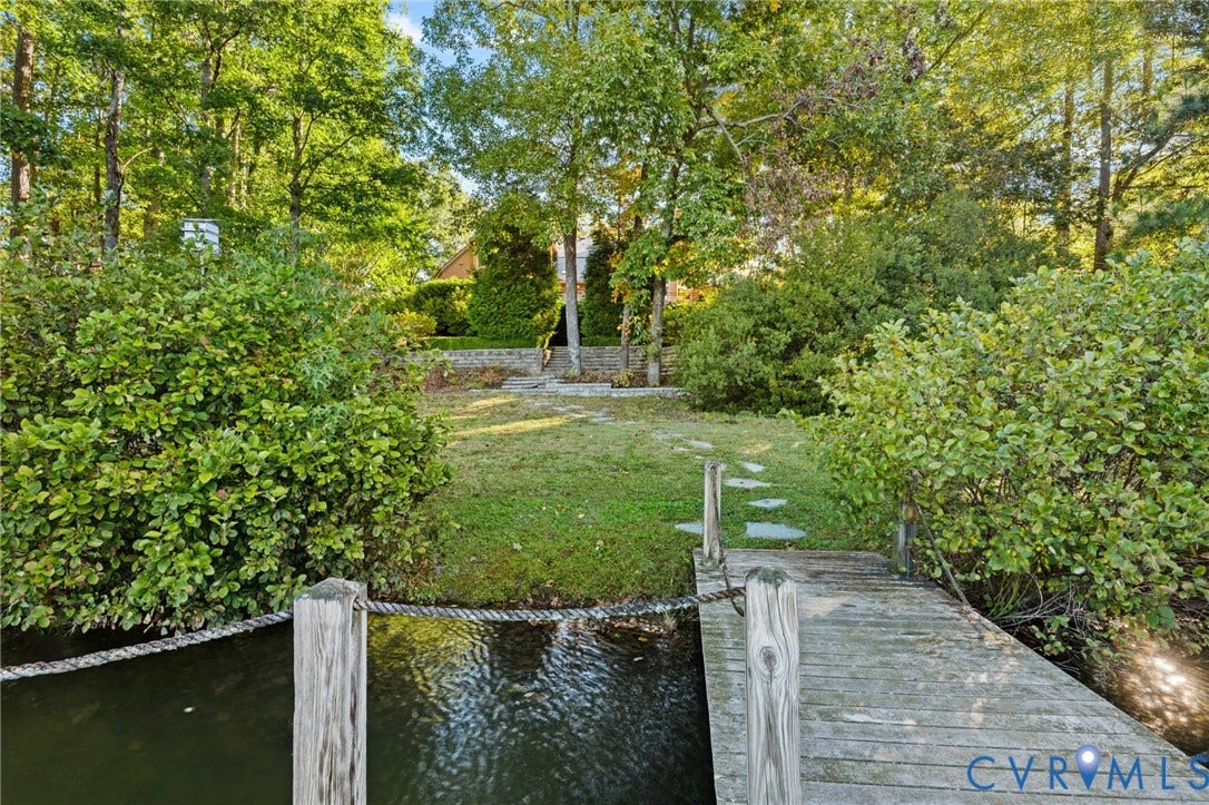 11429 Barrington Bridge Court, Henrico, VA 23233 Waterfront property featuring a wooden dock, stone pathway, grass lawn, and mature trees