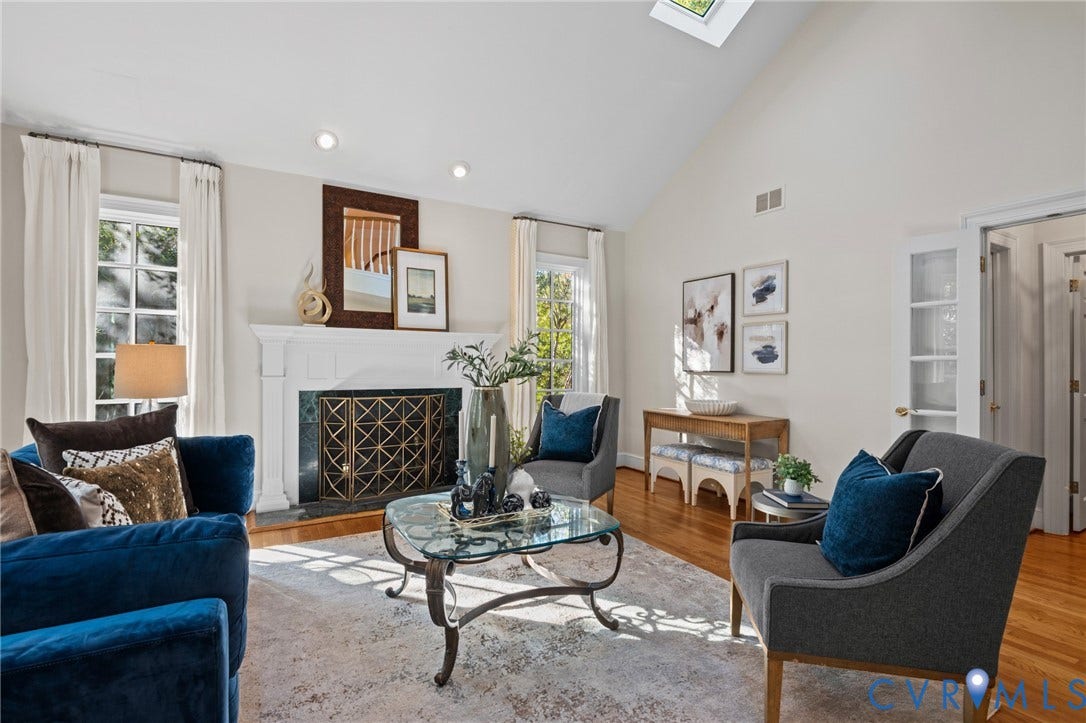 11429 Barrington Bridge Court, Henrico, VA 23233 Vaulted ceiling with skylight, wood-finish flooring, and a fireplace featuring a white mantel and dark stone surround