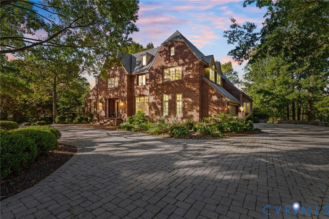 11429 Barrington Bridge Court, Henrico, VA 23233 Multi-story brick exterior featuring a steeply pitched roof, gabled dormers, multi-pane windows, and a paved stone driveway