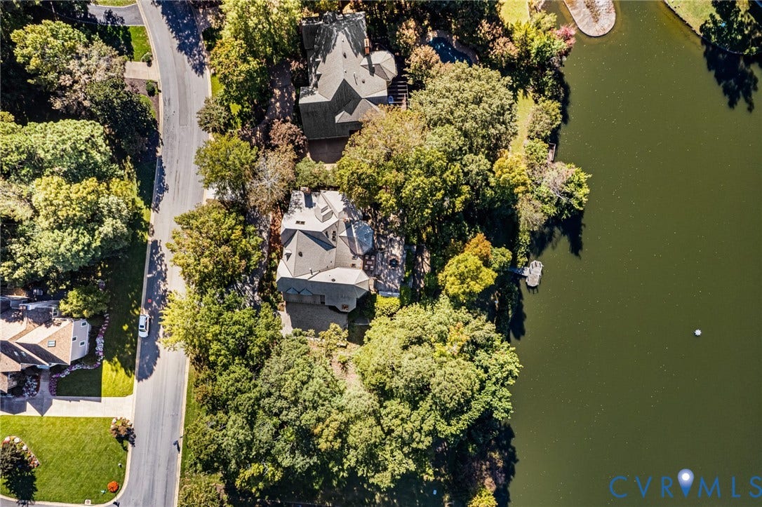 11429 Barrington Bridge Court, Henrico, VA 23233 Aerial perspective featuring a multi-pitched roofline, paved driveway, mature wooded canopy, and private shoreline access to the water