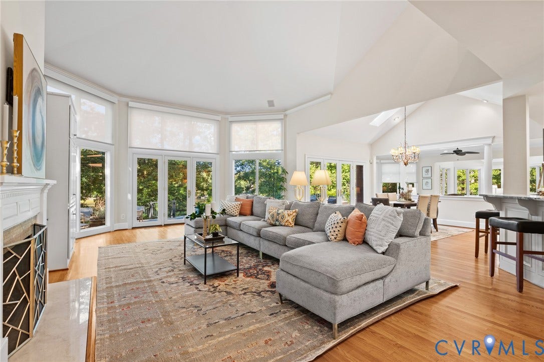 11429 Barrington Bridge Court, Henrico, VA 23233 Vaulted ceilings, expansive windows with exterior glass doors, wood-finish flooring, and a fireplace with a decorative metal screen