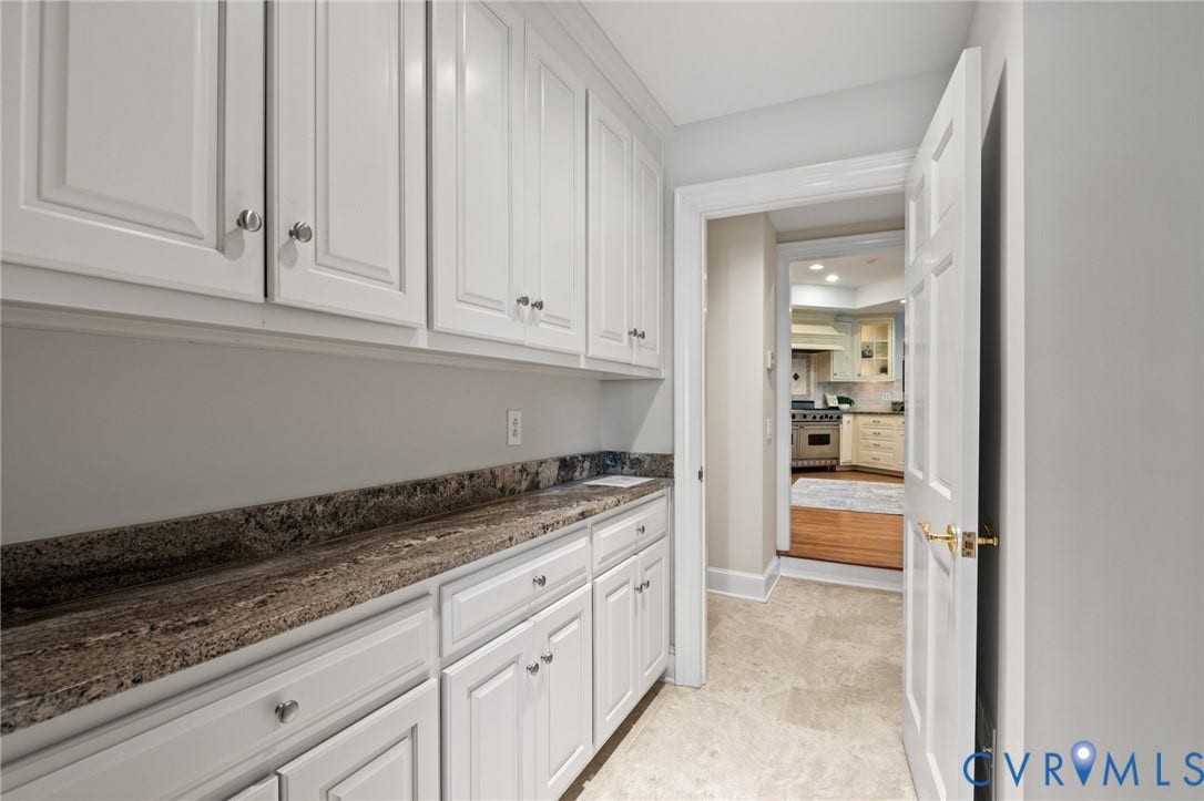 11429 Barrington Bridge Court, Henrico, VA 23233 Custom white cabinetry featuring shaker-style doors, natural stone countertop, tile flooring, and a six-panel interior door