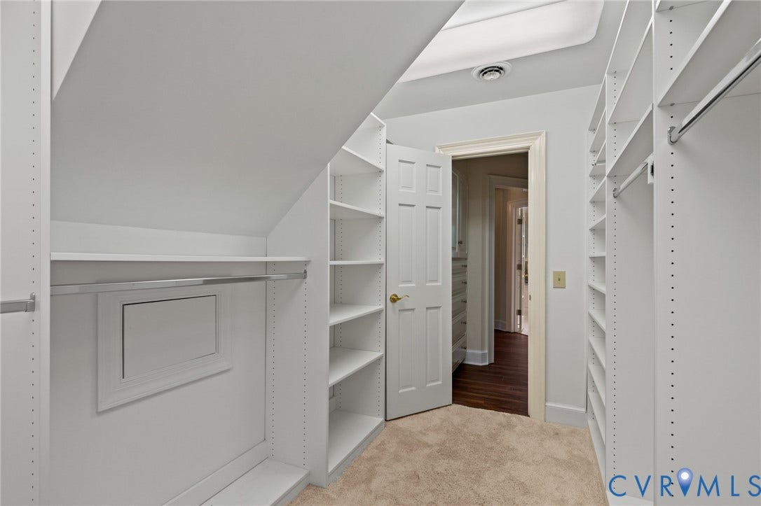 11429 Barrington Bridge Court, Henrico, VA 23233 Custom walk-in closet featuring floor-to-ceiling white shelving, adjustable hanging rods, and integrated skylight lighting