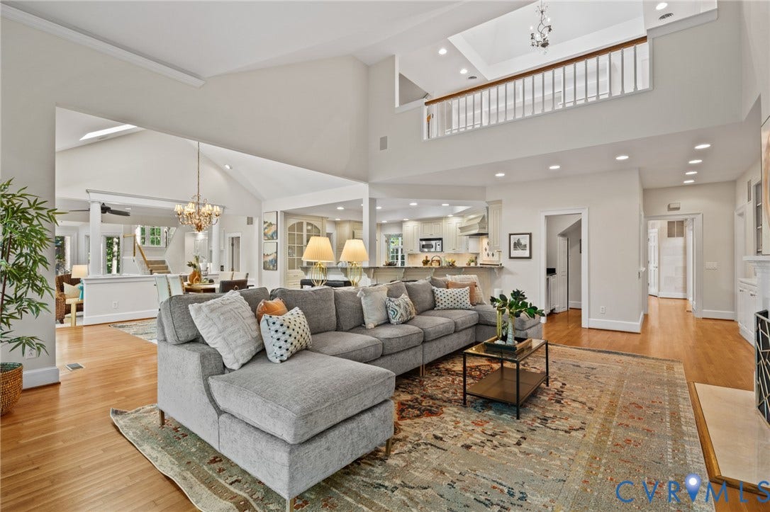11429 Barrington Bridge Court, Henrico, VA 23233 Open-concept interior featuring vaulted ceilings, wood-finish flooring, a mezzanine balcony with a wooden railing, recessed lighting, and a crystal chandelier