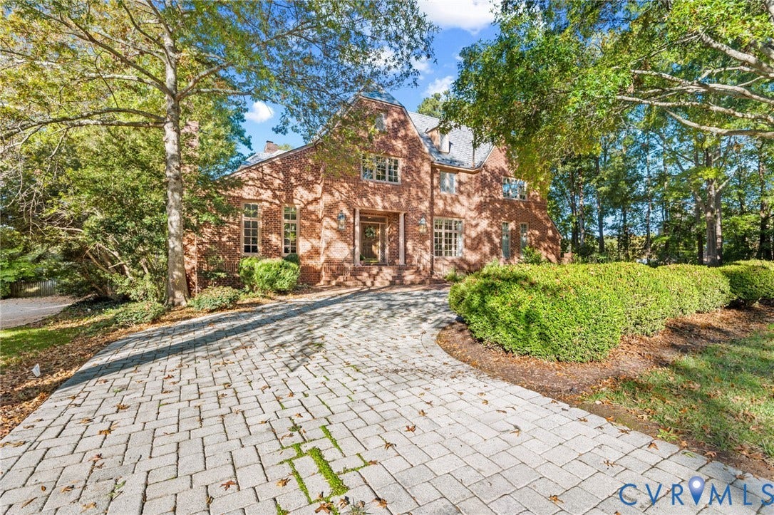 11429 Barrington Bridge Court, Henrico, VA 23233 Two-story brick exterior featuring a steeply pitched roofline, multi-pane windows, and a paved stone driveway