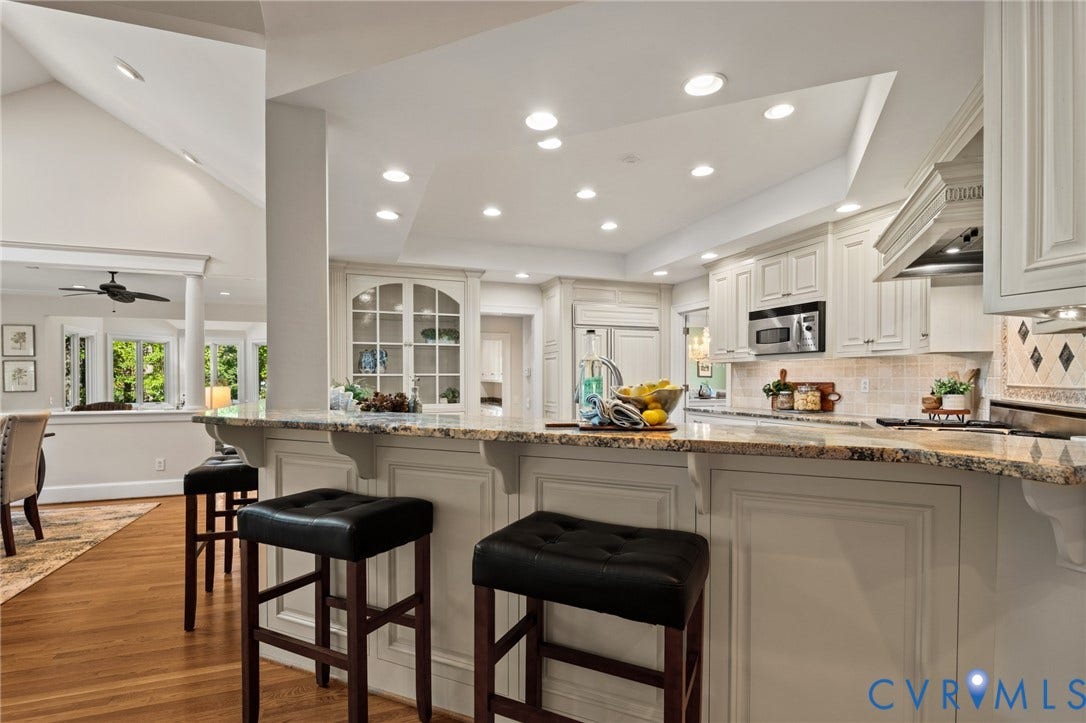 11429 Barrington Bridge Court, Henrico, VA 23233 Kitchen featuring a multi-level stone countertop, custom white cabinetry, built-in glass-front display hutch, recessed lighting, and wood-finish flooring