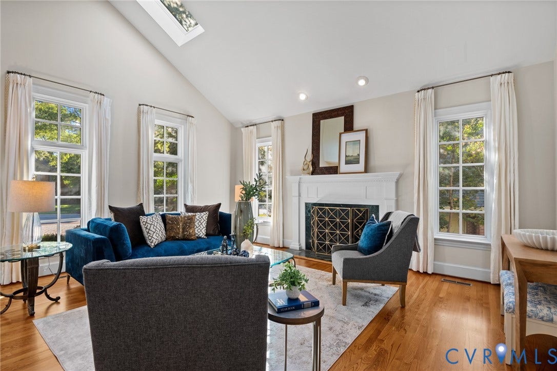 11429 Barrington Bridge Court, Henrico, VA 23233 Living area featuring a vaulted ceiling with a skylight, wood-finish flooring, and a fireplace with a decorative mantel and surround