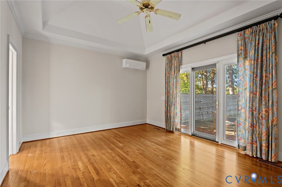 11429 Barrington Bridge Court, Henrico, VA 23233 Tray ceiling with crown molding, wood-finish flooring, wall-mounted ductless HVAC unit, ceiling fan, and sliding glass doors