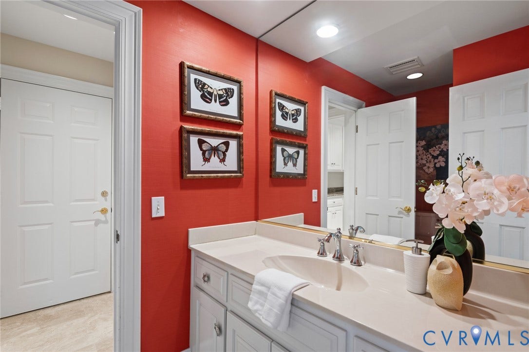 11429 Barrington Bridge Court, Henrico, VA 23233 White cabinetry featuring polished metal hardware, integrated vanity with a molded basin, quartz countertop, and full-width wall mirror