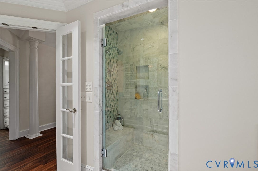 11429 Barrington Bridge Court, Henrico, VA 23233 Walk-in shower featuring a glass door, stone-tile surround, built-in bench seating, mosaic accent wall, and recessed shelving