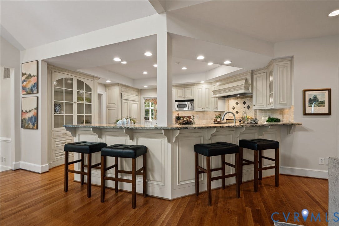 11429 Barrington Bridge Court, Henrico, VA 23233 Kitchen featuring custom cabinetry, a stone-surfaced breakfast bar, recessed lighting, wood-finish flooring, and a built-in china display cabinet