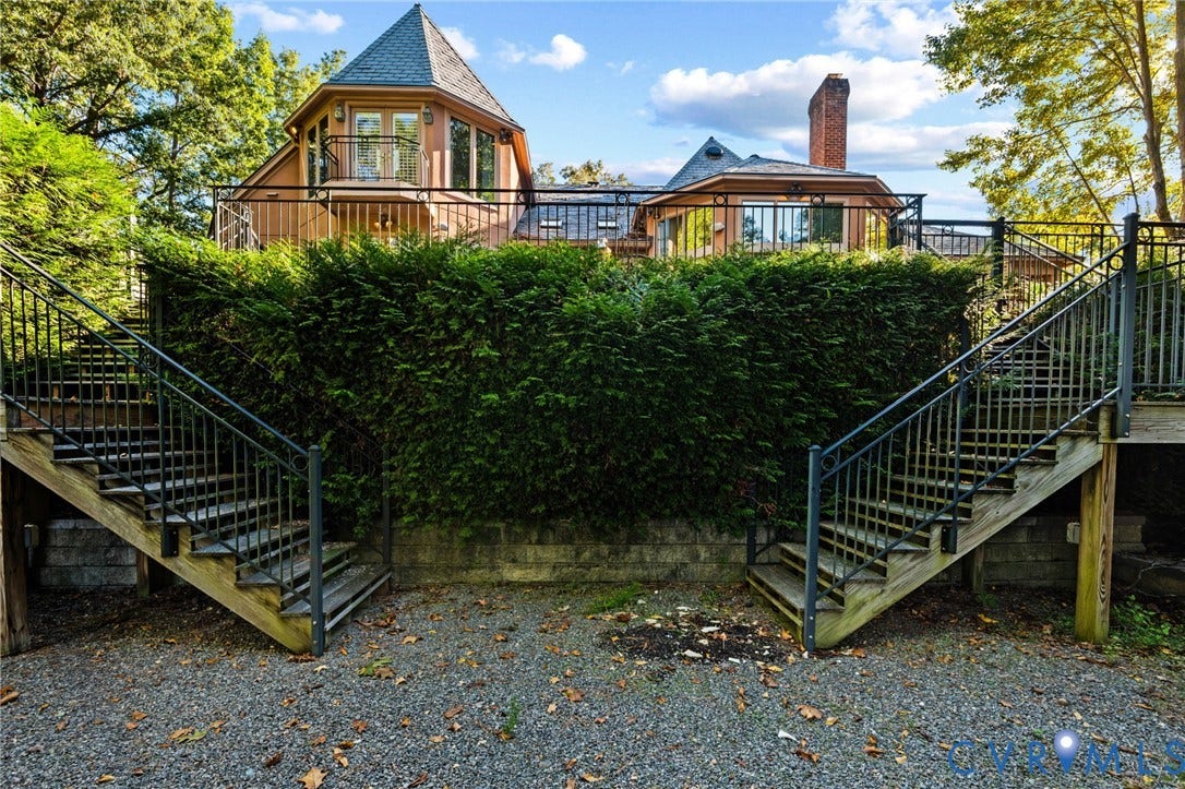 11429 Barrington Bridge Court, Henrico, VA 23233 Exterior featuring multi-level rear decking with metal railings, dual wooden staircases, a turret-style roofline, and a stone retaining wall