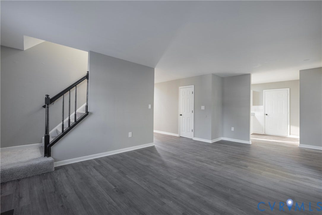 7009 Summers Trace Court, Chesterfield, VA 23832 Open-concept with new flooring, neutral wall paint, and a staircase with a black handrail and balusters