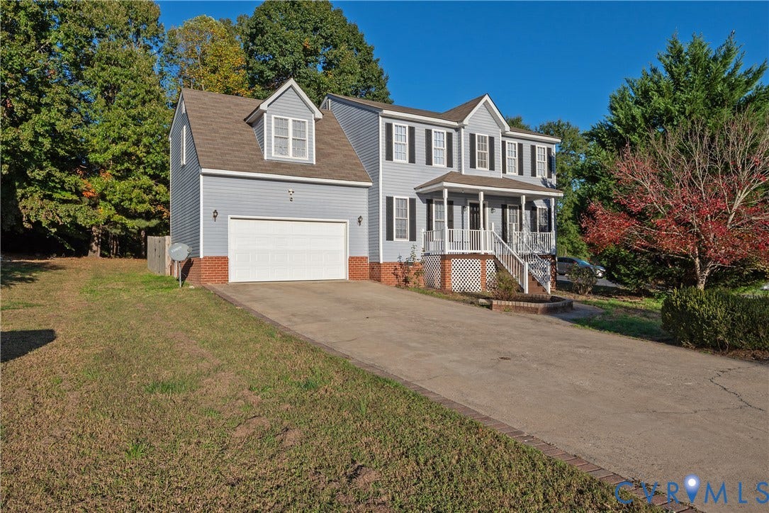 7009 Summers Trace Court, Chesterfield, VA 23832 Two-story exterior featuring blue siding, a brick foundation, a front porch with white railing, and an attached two-car garage