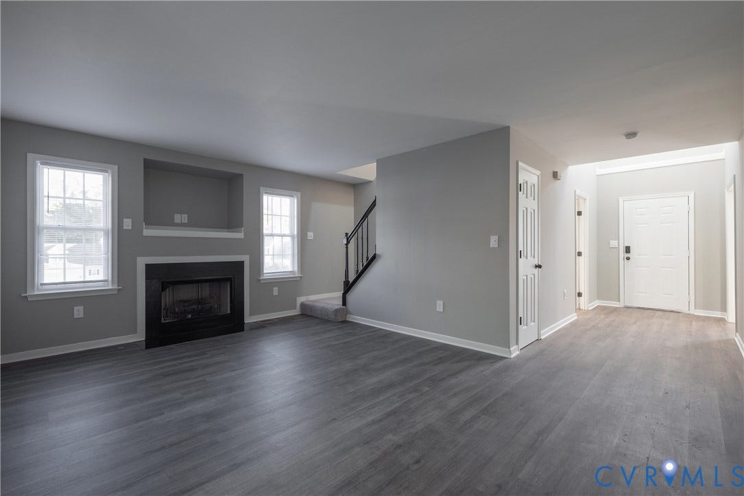 7009 Summers Trace Court, Chesterfield, VA 23832 Family Room with a fireplace and recessed media niche, and a staircase featuring a black balustrade