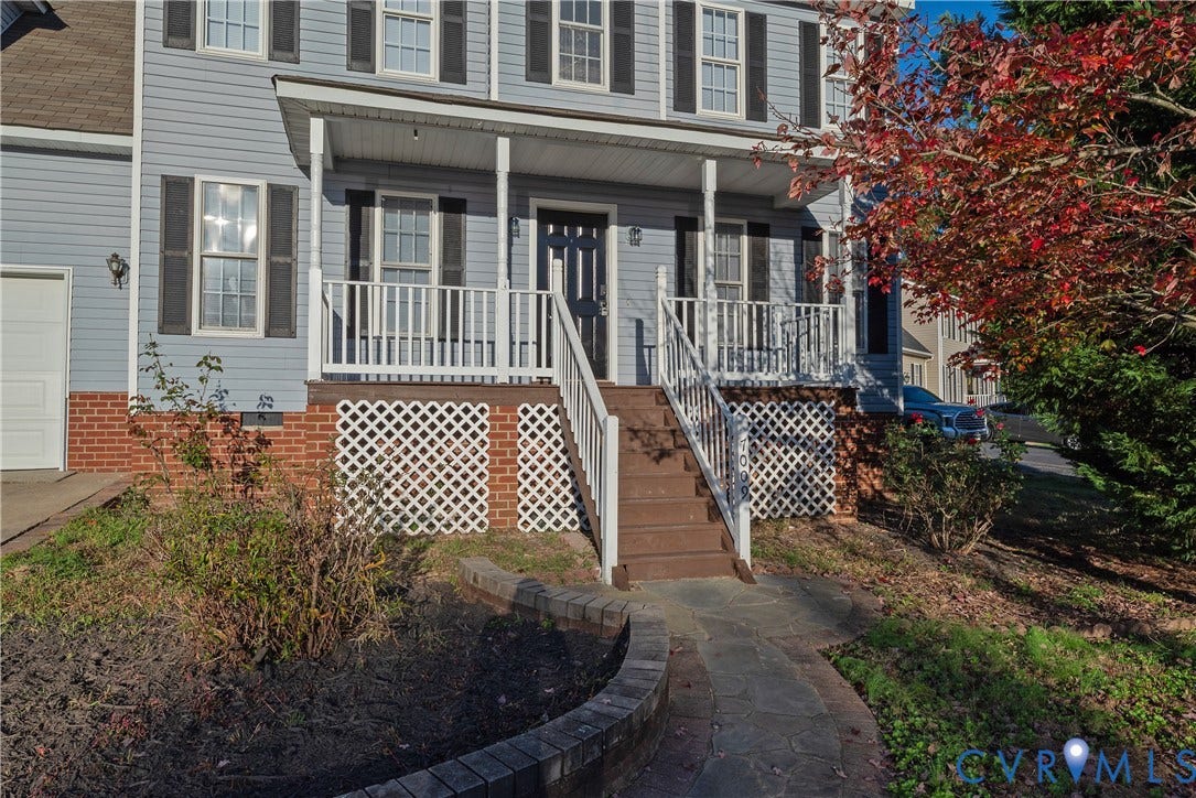 7009 Summers Trace Court, Chesterfield, VA 23832 Colonial-style exterior featuring lap siding, a covered front porch with white railing, brick foundation skirting, decorative lattice panels, and a stone walkway
