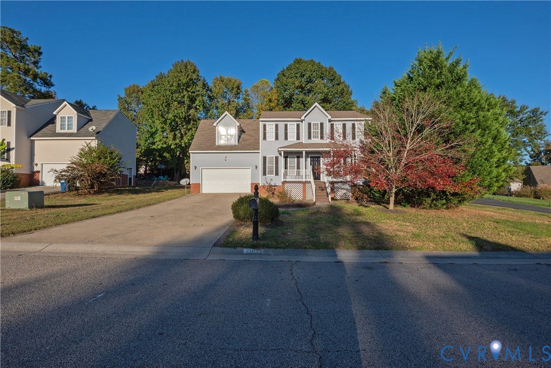 7009 Summers Trace Court, Chesterfield, VA 23832 Two-story colonial exterior featuring vinyl siding, a covered front porch, decorative window shutters, an attached two-car garage, and a concrete driveway