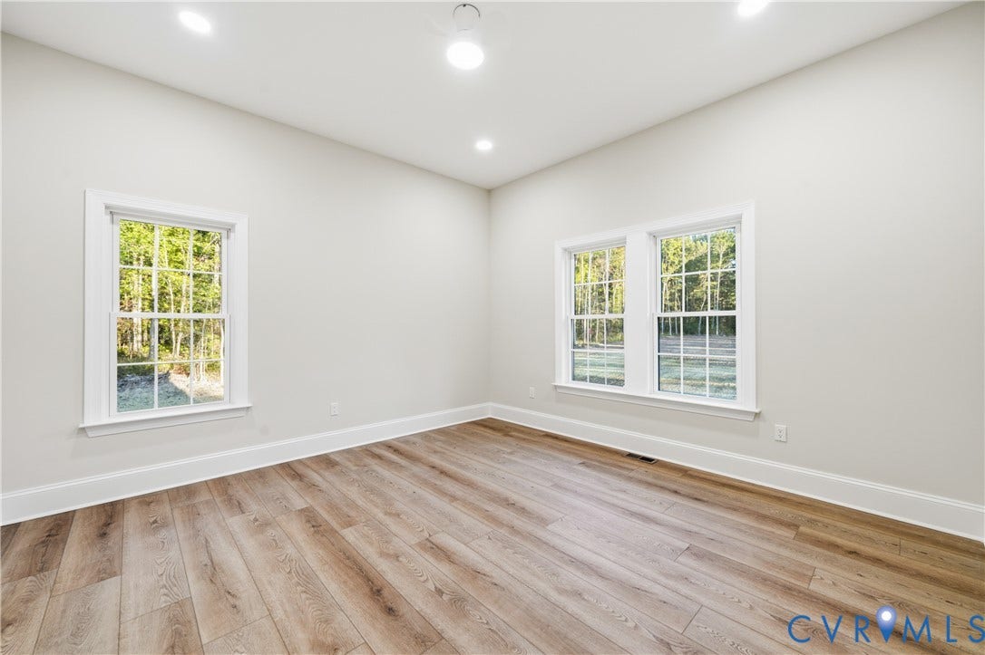 Neutral interior featuring wood-finish flooring, recessed lighting, and multi-pane windows