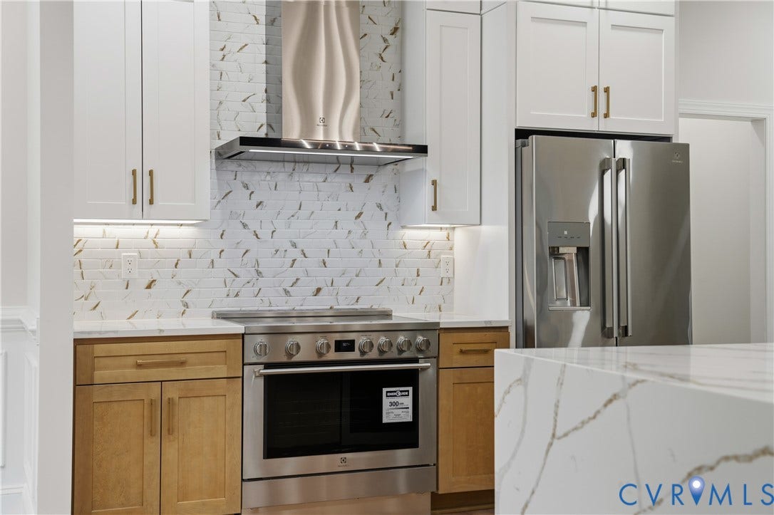 Kitchen featuring shaker-style cabinetry, stainless steel appliances, a decorative tile backsplash, a stainless steel range hood, and a stone-surface island countertop