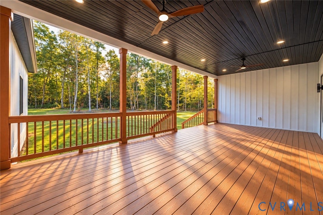 Covered deck featuring wood-finish composite decking, vertical board-and-batten siding, a dark-toned tongue-and-groove ceiling, recessed lighting, and ceiling fans