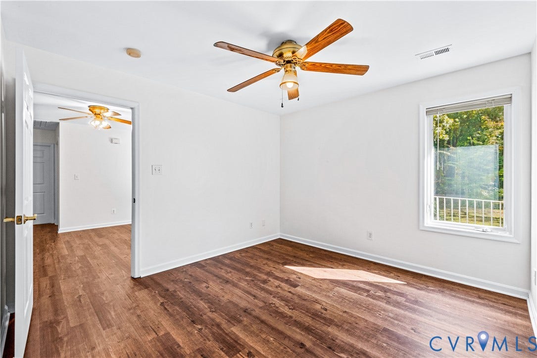 20040 Paradise Lane, Ruther Glen, VA 22546 Wood-finish flooring, neutral wall tones, multi-blade ceiling fan, and a double-hung window featuring natural exterior scenery