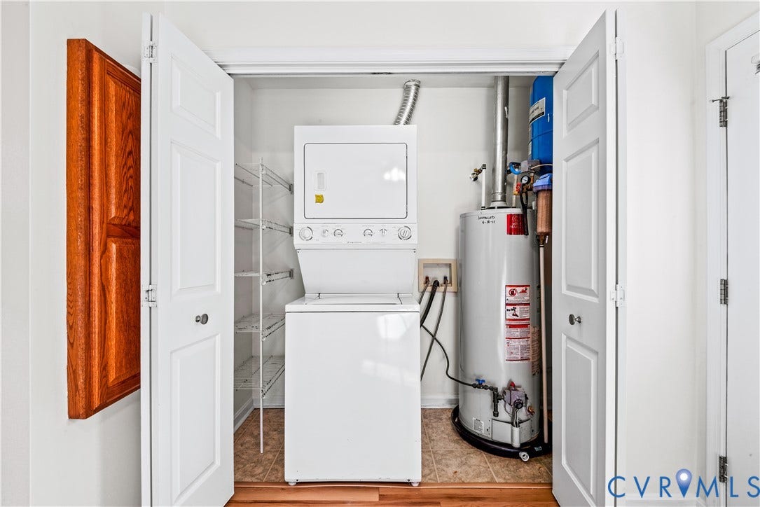 20040 Paradise Lane, Ruther Glen, VA 22546 Utility closet containing a stacked laundry unit, vertical water heater, and built-in wire shelving