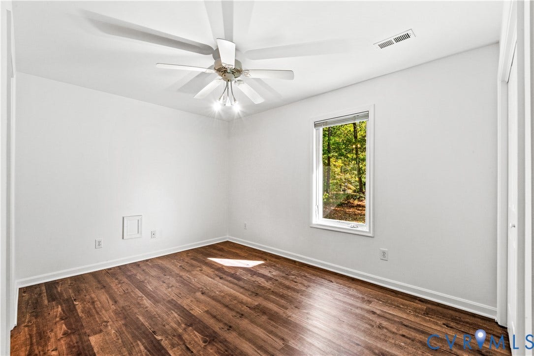 20040 Paradise Lane, Ruther Glen, VA 22546 Interior space featuring wood-finish flooring, a multi-blade ceiling fan with integrated lighting, and a single-pane window with a forest exterior