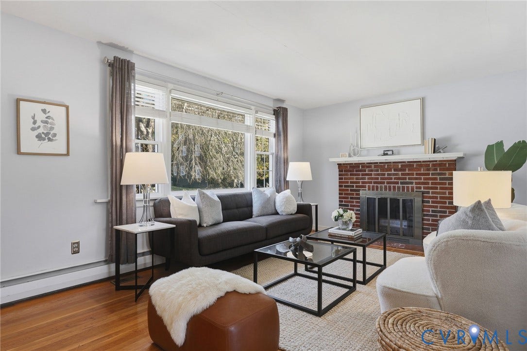 5028 Devonshire Road, Richmond, VA 23225 Living area featuring wood-finish flooring, a brick fireplace with a mantel, and a multi-pane window