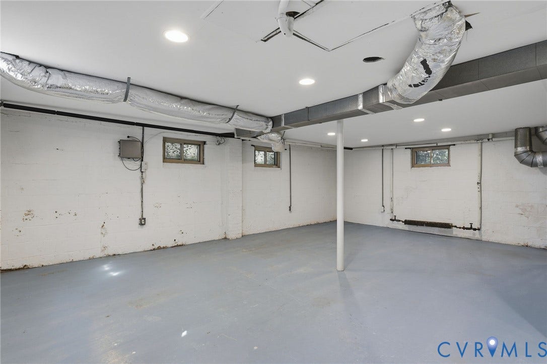 5028 Devonshire Road, Richmond, VA 23225 Open-concept interior space featuring painted masonry walls, sealed concrete flooring, recessed lighting, and multiple windows