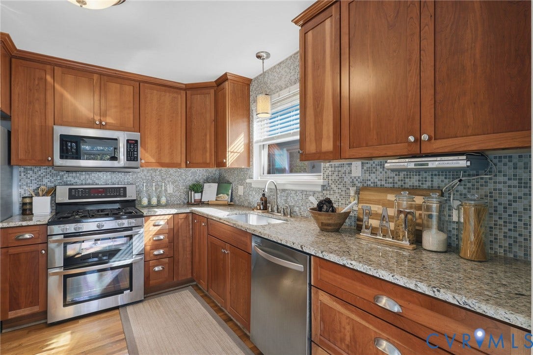 5028 Devonshire Road, Richmond, VA 23225 Kitchen featuring wood cabinetry, stone countertops, mosaic tile backsplash, stainless steel appliances, and a pendant light fixture