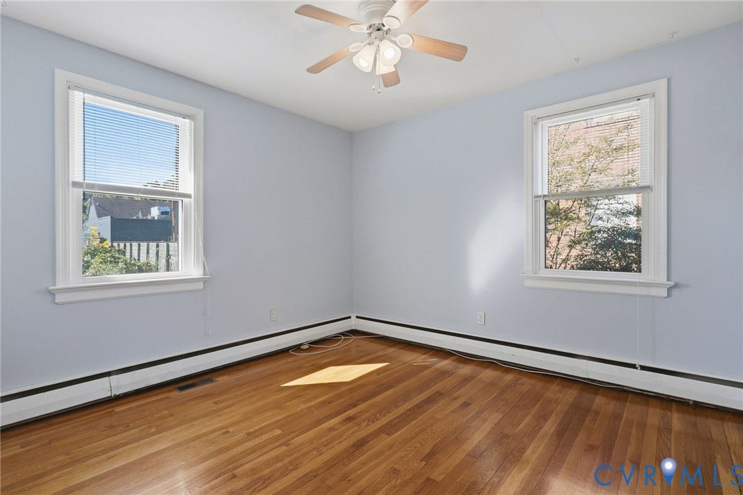 5028 Devonshire Road, Richmond, VA 23225 Interior space featuring wood-finish flooring, two double-hung windows, and a ceiling-mounted light fixture with a fan