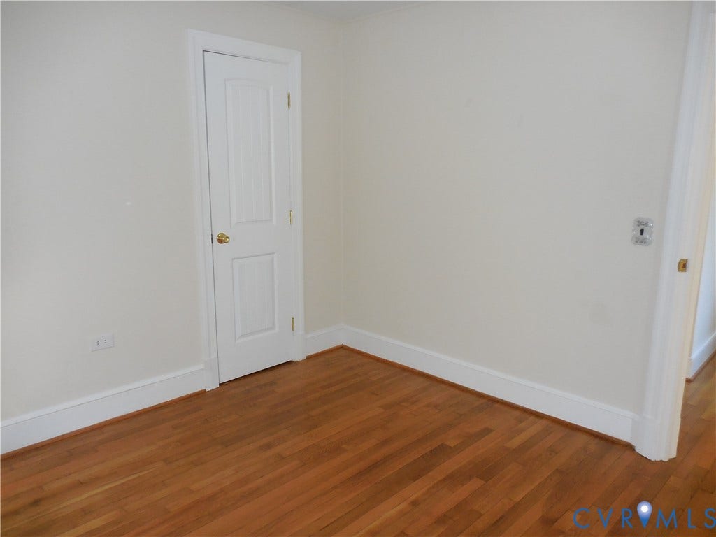25 Bethany Church Road, Bumpass, VA 23024 Interior room featuring wood-finish flooring, white walls, and a two-panel interior door with metallic hardware