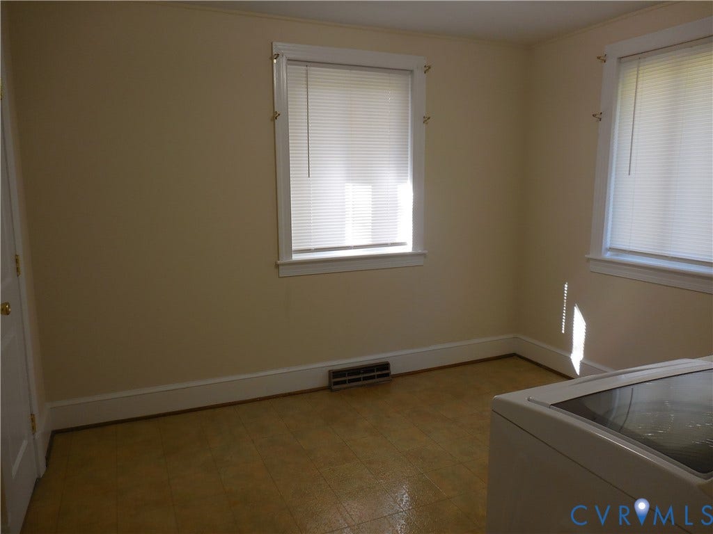 25 Bethany Church Road, Bumpass, VA 23024 Interior space featuring neutral-toned walls, two windows with horizontal blinds, and tile flooring