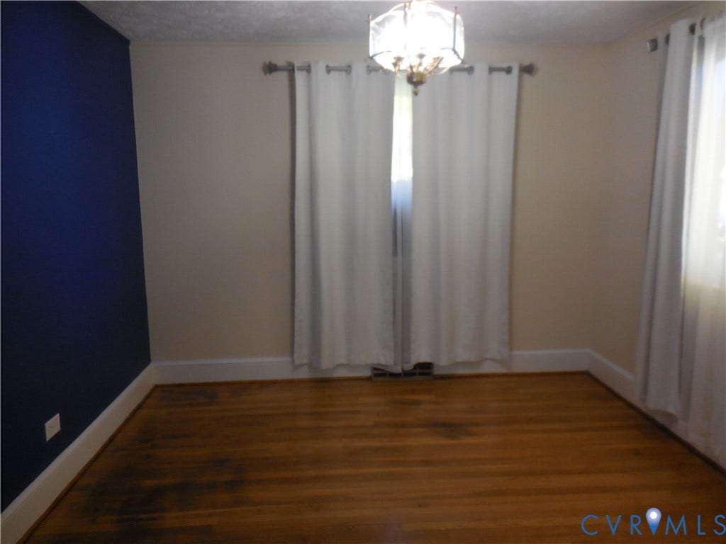 25 Bethany Church Road, Bumpass, VA 23024 Hardwood flooring, decorative hanging light fixture, and an accent wall