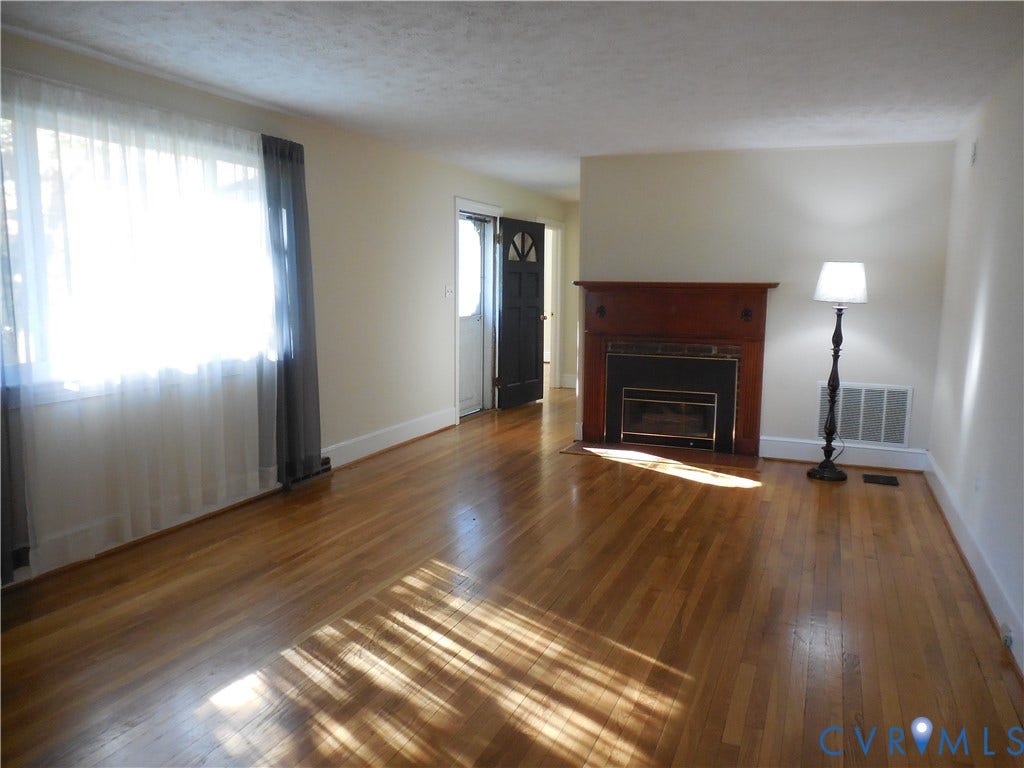 25 Bethany Church Road, Bumpass, VA 23024 Living area featuring wood-finish flooring, a fireplace with a wood mantel, and large windows