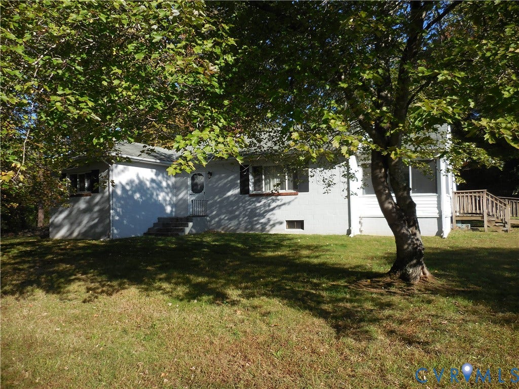 25 Bethany Church Road, Bumpass, VA 23024 Light-colored exterior siding with contrasting shutters, multi-pane windows, elevated wooden deck, and mature shade trees