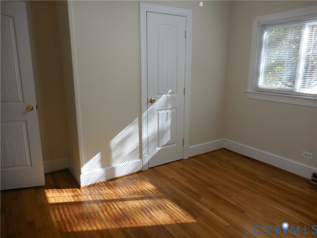 25 Bethany Church Road, Bumpass, VA 23024 Room featuring wood-finish flooring, two-panel interior doors with brass-tone hardware, and window with white casing
