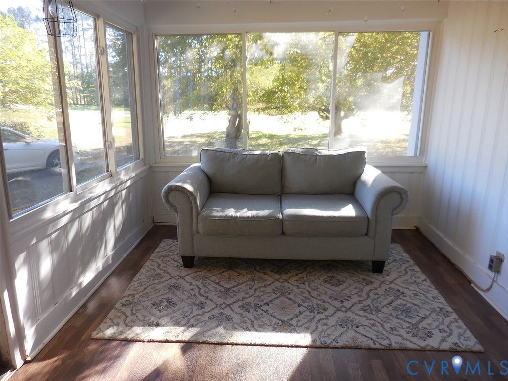 25 Bethany Church Road, Bumpass, VA 23024 Enclosed sunroom featuring expansive windows, wood-finish flooring, and vertical wall paneling