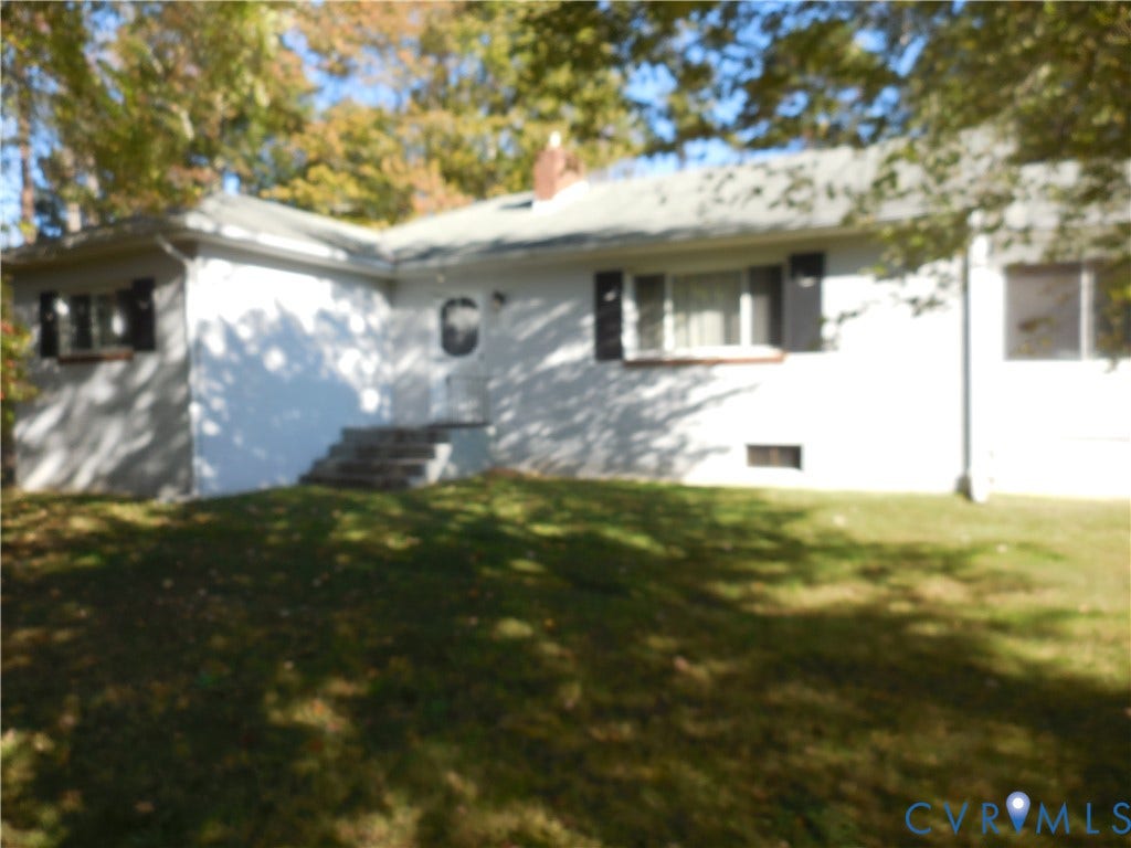 25 Bethany Church Road, Bumpass, VA 23024 Single-story residence featuring a light-colored exterior, dark window shutters, a brick chimney, and concrete entryway steps