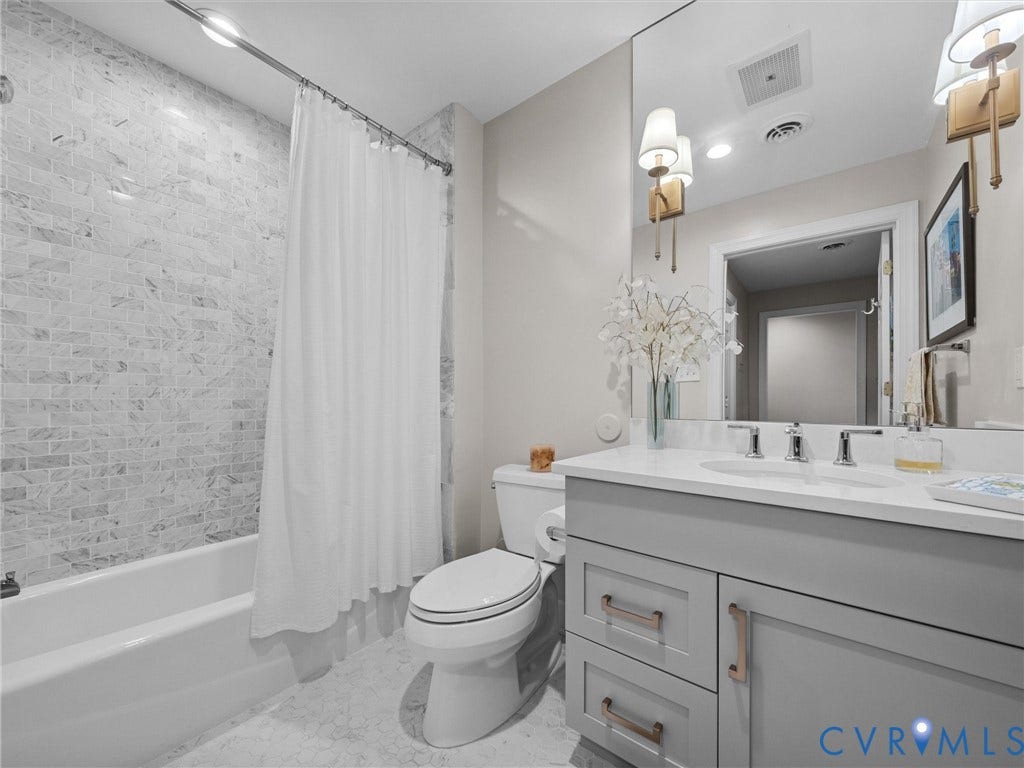 413 Stuart Circle, #3B, Historic Fan District, Richmond, VA 23220 Hall bath with tub/shower with marble tile surround and single vanity.
